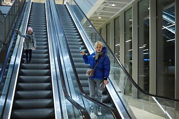 Image showing Mother and child together on escalator background. Terminal, airport travel, love care.