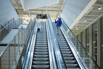 Image showing Mother and child together on escalator background. Terminal, airport travel, love care.