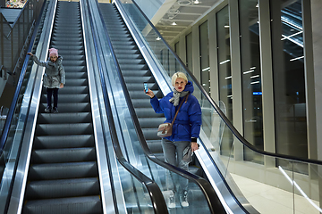 Image showing Mother and child together on escalator background. Terminal, airport travel, love care.