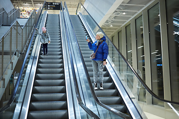Image showing Mother and child together on escalator background. Terminal, airport travel, love care.