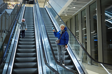 Image showing Mother and child together on escalator background. Terminal, airport travel, love care.