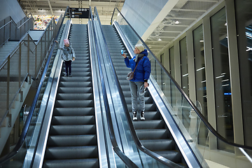 Image showing Mother and child together on escalator background. Terminal, airport travel, love care.