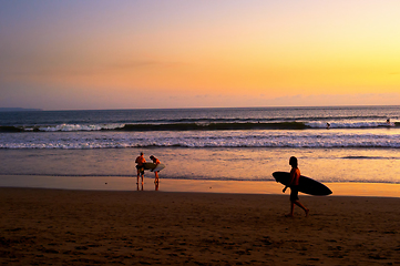 Image showing Surfers on beach at sunset