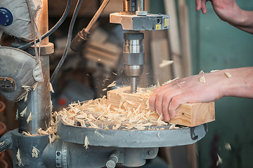 Image showing Carpenters with electric drill machine drilling wooden board