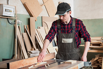 Image showing Carpenter worker cutting wooden board