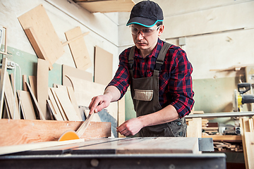 Image showing Carpenter worker cutting wooden board