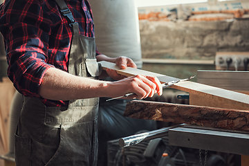 Image showing Carpenter worker cutting wooden board