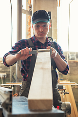 Image showing The worker makes measurements of a wooden board