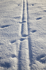 Image showing narrow village road with traces of transport wheels in the snow, winter time in nature