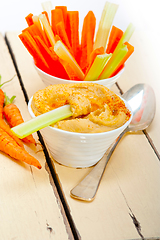 Image showing fresh hummus dip with raw carrot and celery
