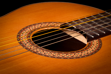 Image showing Classical guitar close up on dark