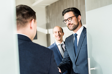 Image showing Group of confident business people greeting with a handshake at business meeting in modern office or closing the deal agreement by shaking hands.