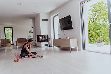 Image showing Young Beautiful Female Woman with Trainer via Video Call Conference in Bright Sunny House. Healthy Lifestyle, Wellbeing and Mindfulness Concept.