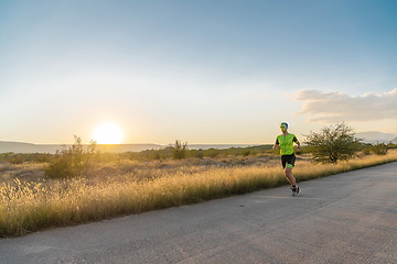 Image showing Triathlete in professional gear running early in the morning, preparing for a marathon, dedication to sport and readiness to take on the challenges of a marathon.