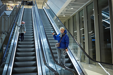 Image showing Mother and child together on escalator background. Terminal, airport travel, love care.