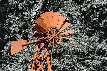 Image showing Wind powered water pump with rusty pipes