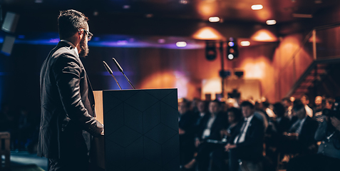 Image showing Speaker giving a talk on corporate business conference. Unrecognizable people in audience at conference hall. Business and Entrepreneurship event