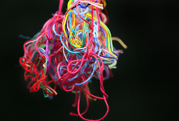 Image showing Ball of multicolored tangled threads for needlework on black bac