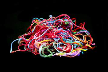 Image showing Ball of multicolored tangled threads for needlework on black bac