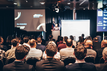 Image showing Speaker giving a talk in conference hall at business event. Rear view of unrecognizable people in audience at the conference hall. Business and entrepreneurship concept.