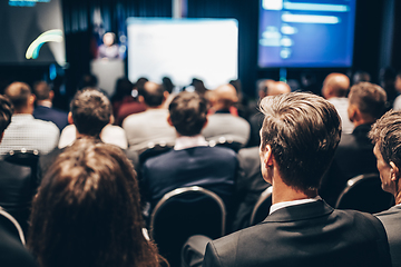 Image showing Speaker giving a talk in conference hall at business event. Rear view of unrecognizable people in audience at the conference hall. Business and entrepreneurship concept.