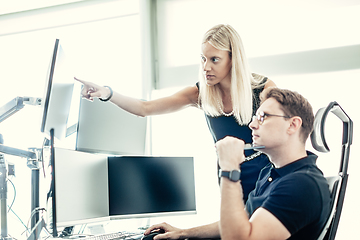 Image showing Stock broker business team trading online watching charts and data analyses on multiple computer screens in modern corporate work station office.