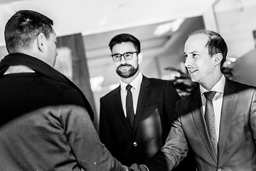 Image showing Group of confident business people greeting with a handshake at business meeting in modern office or closing the deal agreement by shaking hands.