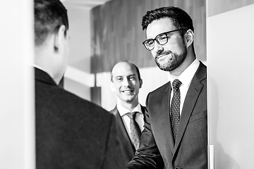 Image showing Group of confident business people greeting with a handshake at business meeting in modern office or closing the deal agreement by shaking hands.