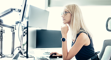 Image showing Female financial assets manager, trading online, watching charts and data analyses on multiple computer screens. Modern corporate business woman concept.