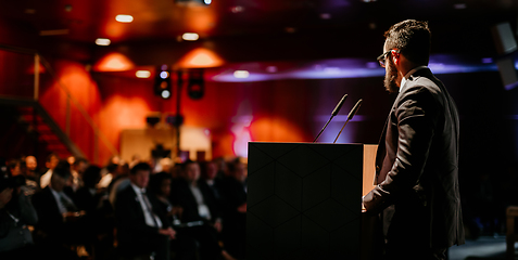 Image showing Speaker giving a talk on corporate business conference. Unrecognizable people in audience at conference hall. Business and Entrepreneurship event