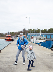 Image showing Daughter and mother have fun on pier.