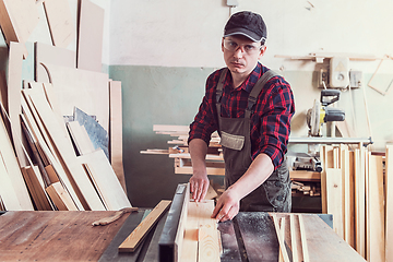 Image showing Carpenter worker cutting wooden board