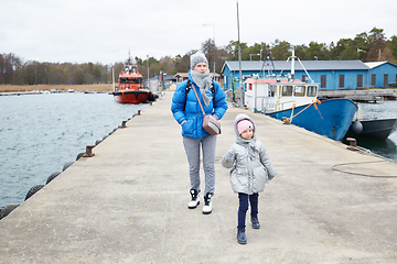 Image showing Daughter and mother have fun on pier.