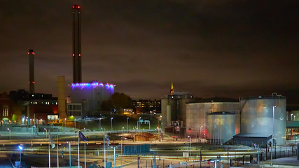 Image showing Modern grain terminal at night. Metal tanks of elevator. Grain-drying complex construction. Commercial grain or seed silos at seaport. Steel storage for agricultural harvest