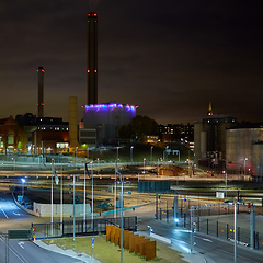 Image showing Modern grain terminal at night. Metal tanks of elevator. Grain-drying complex construction. Commercial grain or seed silos at seaport. Steel storage for agricultural harvest