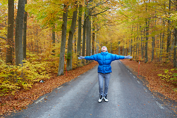 Image showing Young woman posing in the autumn forest on the road.