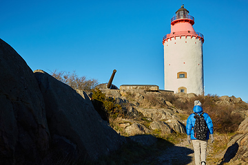 Image showing Beautiful woman posing near lighthouse. Travel the world concept