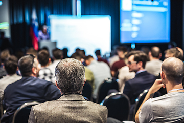 Image showing Speaker giving a talk in conference hall at business event. Rear view of unrecognizable people in audience at the conference hall. Business and entrepreneurship concept.