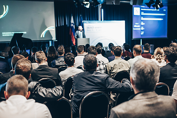 Image showing Speaker giving a talk in conference hall at business event. Rear view of unrecognizable people in audience at the conference hall. Business and entrepreneurship concept.