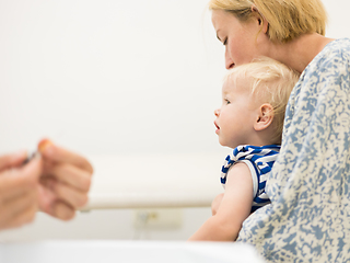 Image showing Child beeing vaccinated by pediatrician in presence of his mother. Preventive vaccination against Diphtheria, whooping cough, tetanus, hepatitis, haemophilus influenzae, pneumococcus, poliomyelitis