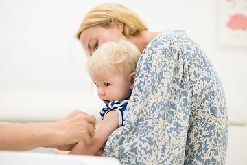 Image showing Child beeing vaccinated by pediatrician in presence of his mother. Preventive vaccination against Diphtheria, whooping cough, tetanus, hepatitis, haemophilus influenzae, pneumococcus, poliomyelitis