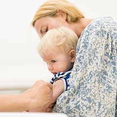 Image showing Child beeing vaccinated by pediatrician in presence of his mother. Preventive vaccination against Diphtheria, whooping cough, tetanus, hepatitis, haemophilus influenzae, pneumococcus, poliomyelitis