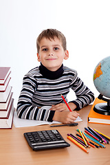 Image showing Cute schoolboy is writting