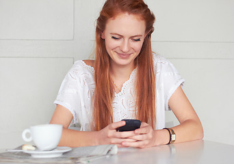 Image showing Coffee shop, phone and happy woman texting, relax and smile for chat app on wall background. Cafe, social media and female customer reading post, news or update while enjoying day off and tea break