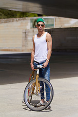 Image showing Street wear, fashion and man with a bicycle in a city for eco friendly or sustainable transport on urban background. Style, attitude and male person posing with a bike for cycling, commute or travel