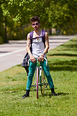 Image showing Fashion, street wear and man with a bicycle in a city for eco friendly or sustainable transport on urban background. Style, attitude and male person posing with a bike for cycling, commute or travel