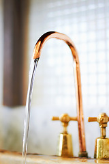 Image showing Faucet, copper and tap with stream of water for cleaning, washing and hygiene in kitchen or bathroom. Plumbing, home decoration and closeup of running liquid, aqua and drops in basin for cleansing