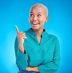 Image showing Excited, direction and happy black woman point at studio logo design, commercial choice or announcement news. Service smile, brand info and African person gesture at discount deal on blue background