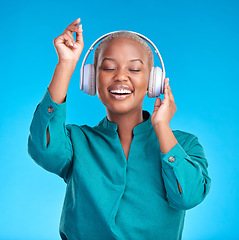 Image showing African woman, headphones and studio for dancing, music or listen with smile by blue background. Young gen z student, sound tech and happy for audio streaming subscription, radio or excited for dance