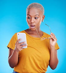 Image showing Shocked, wow and woman reading phone for fake news, wrong email and mistake or scam email. Surprise, stress and african person or online user, social media or mobile problem in studio blue background